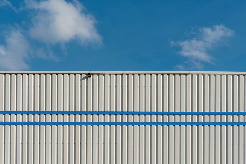 Ribbed metal plant siding against a clear plains sky.
